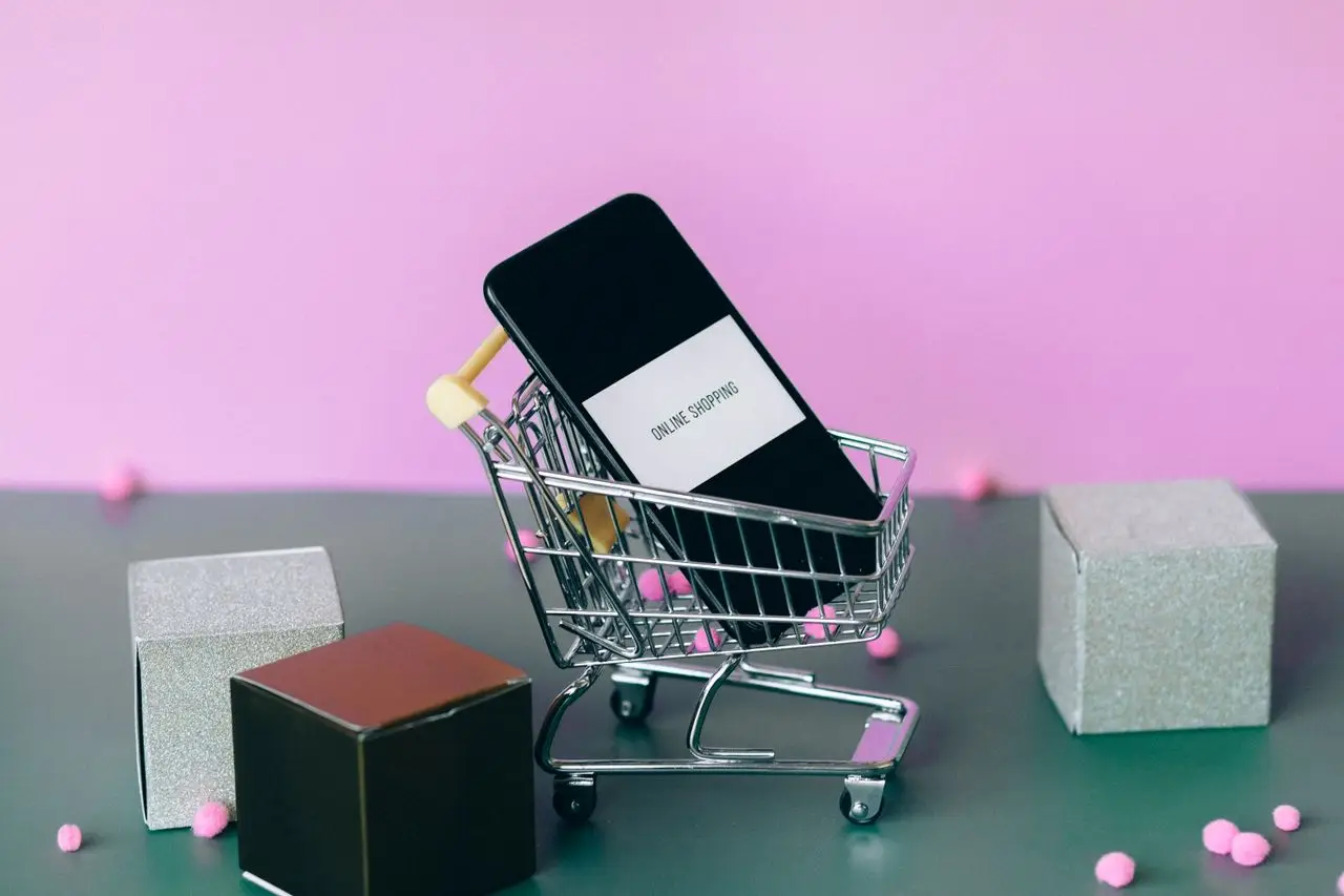 gallery-2 A smartphone with a shopping cart depicting the concept of online shopping in a colorful studio setup.