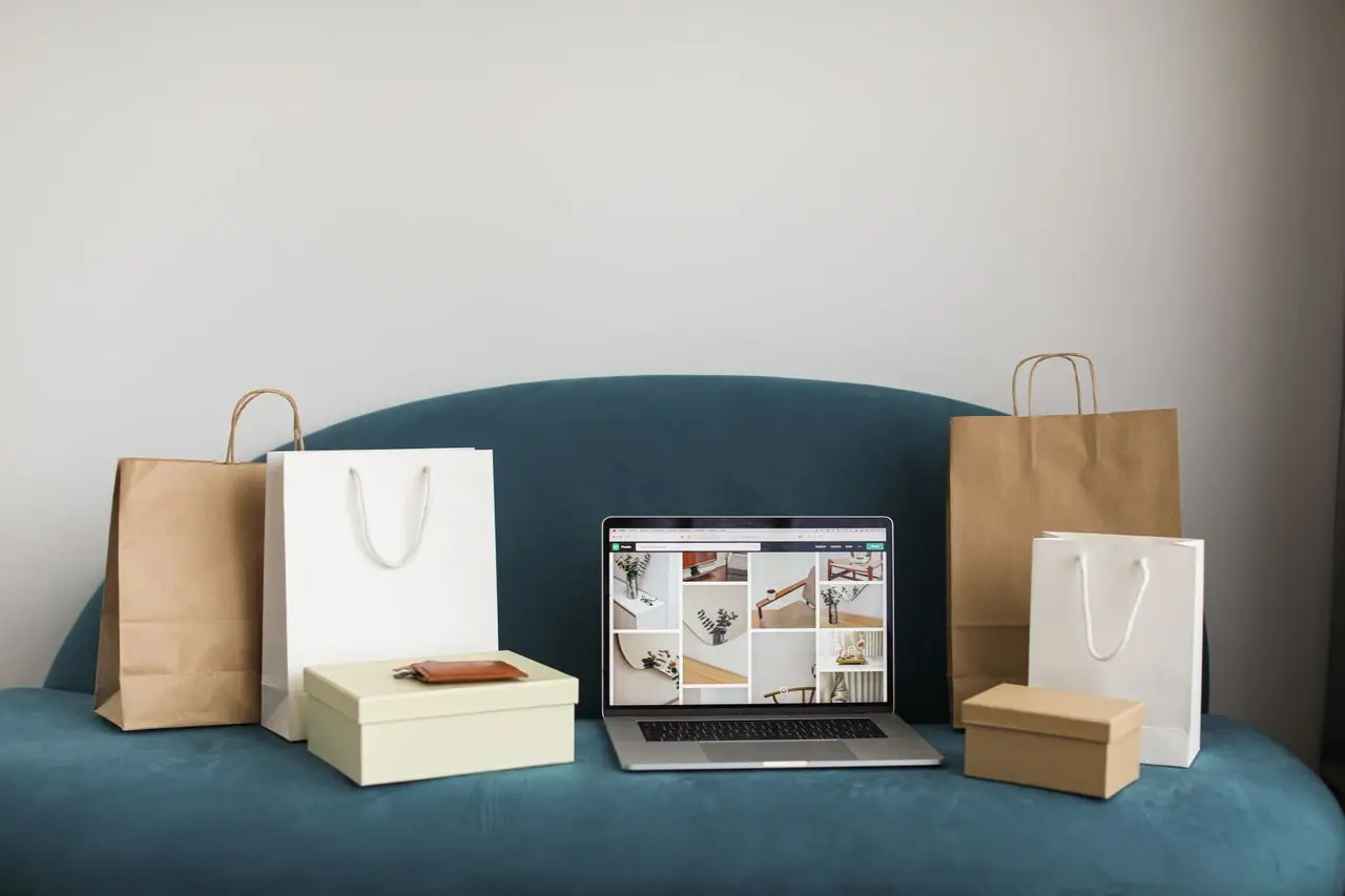 why-choose-us A laptop surrounded by shopping bags and boxes on a blue sofa, ideal for online shopping themes.